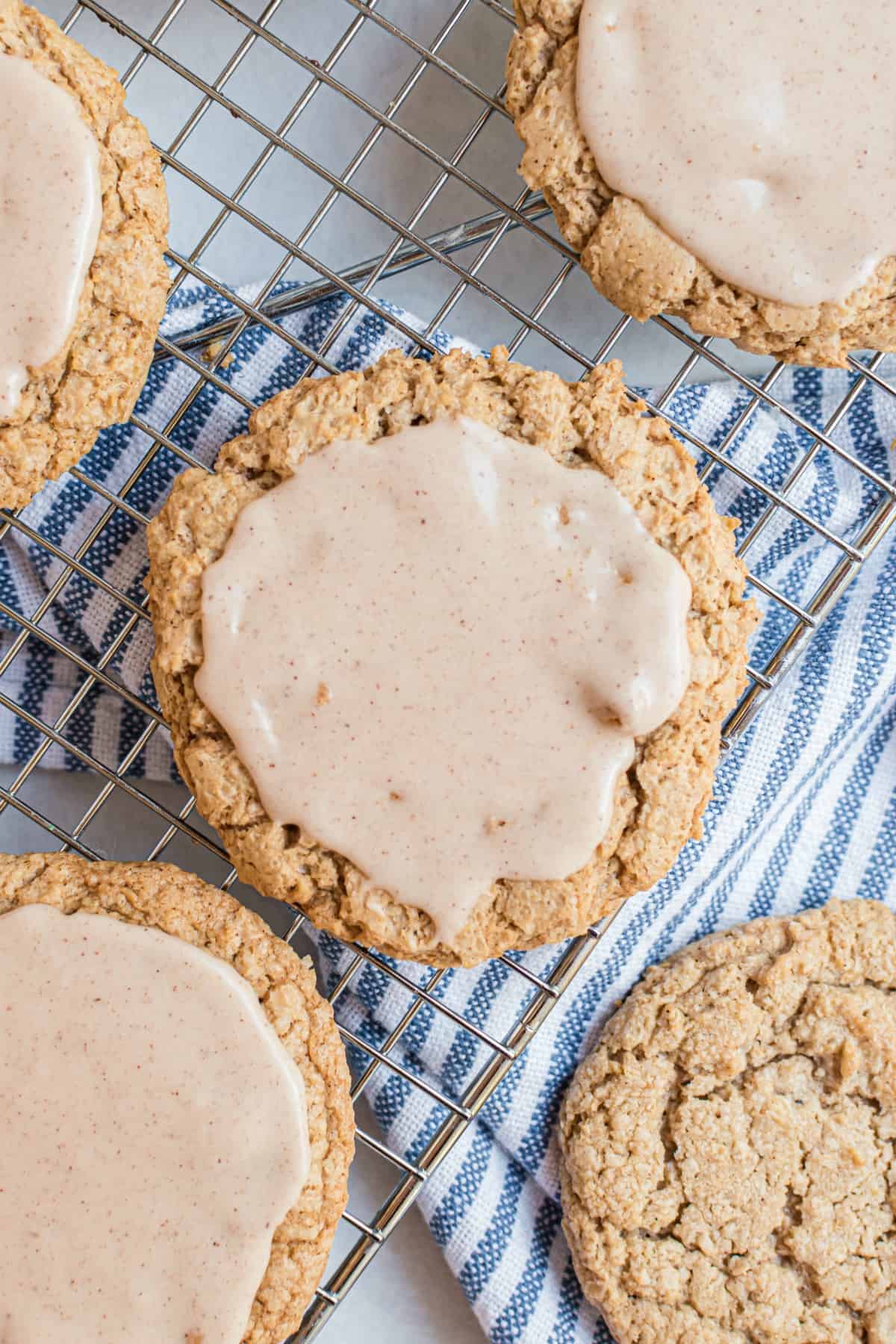 Iced oatmeal cookies on a wire rack.