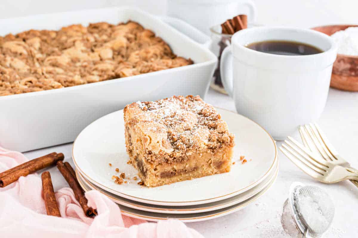 Coffee cake served on a stack of white plates.