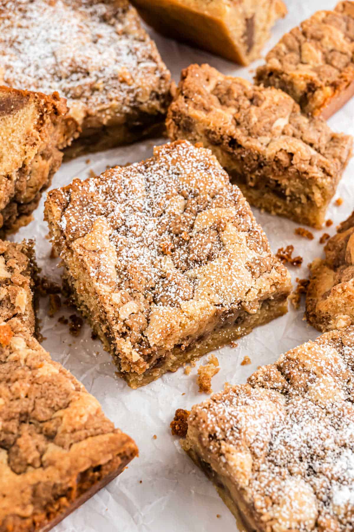 Slices of cinnamon coffee cake on parchment paper.