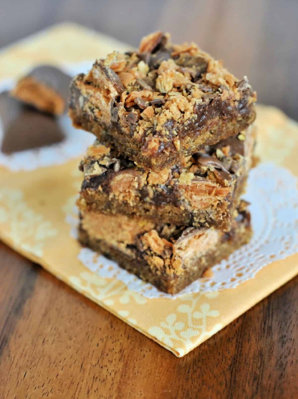 Cookie bars topped with fudge and crushed Butterfinger candies.
