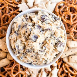 Peanut butter cookie dough dip in a bowl served with pretzels and animal crackers.