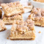 Snickerdoodle Cheesecake Bars are like cookies and cheesecake in one! A homemade graham cracker crust is topped with a creamy cheesecake layer and snickerdoodle cookie dough in this sweet and salty recipe.