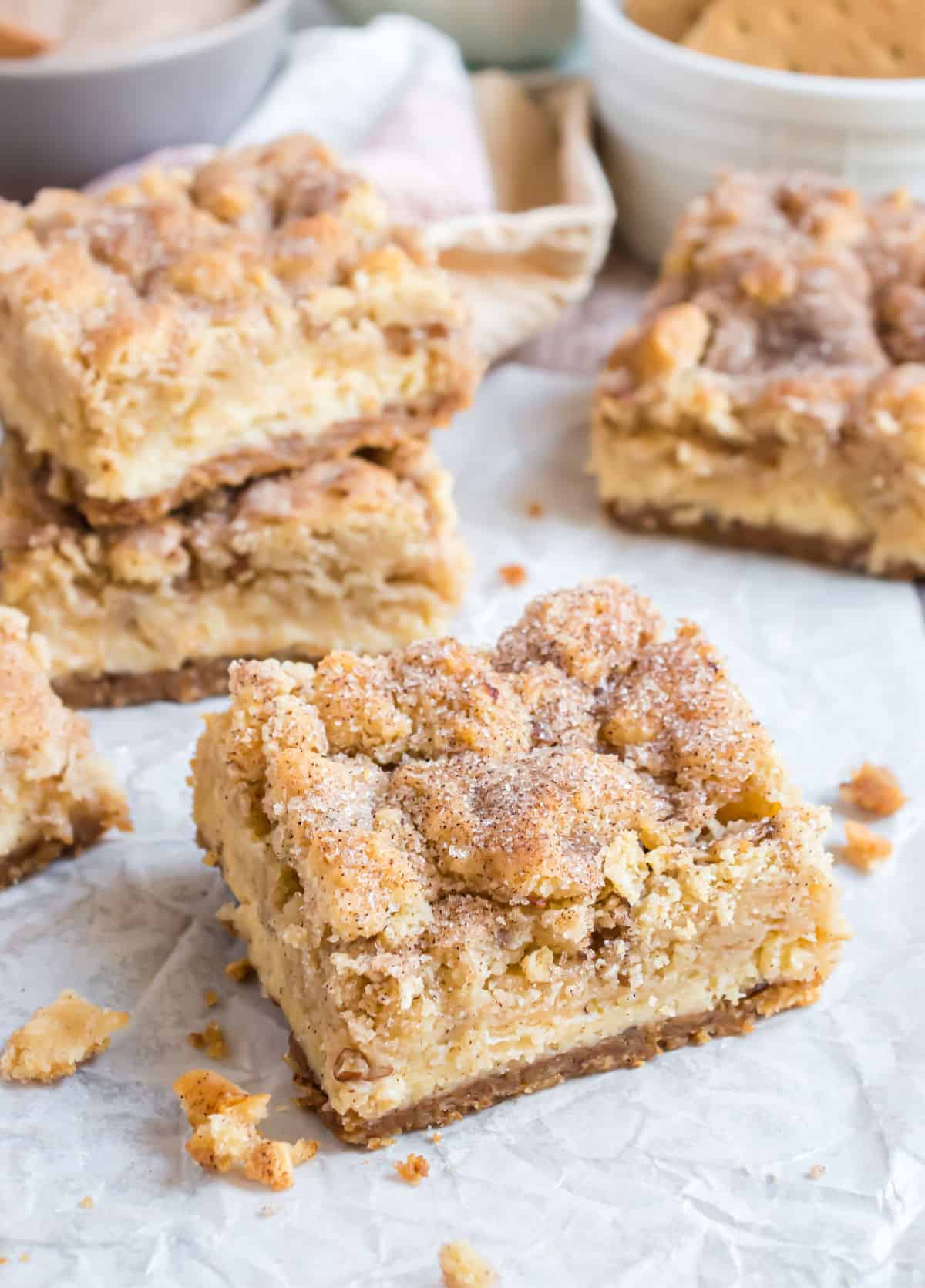 Cheesecake bars topped with snickerdoodle cookie dough cut into bars.