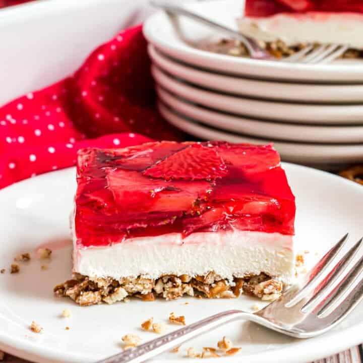 This Strawberry Pretzel Salad recipe is the perfect sweet and salty combination! A light cream cheese filling, crunchy pretzel crust and fresh strawberry JELLO topping make these bars totally irresistible.