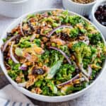 Broccoli salad with creamy dressing in a white serving bowl.