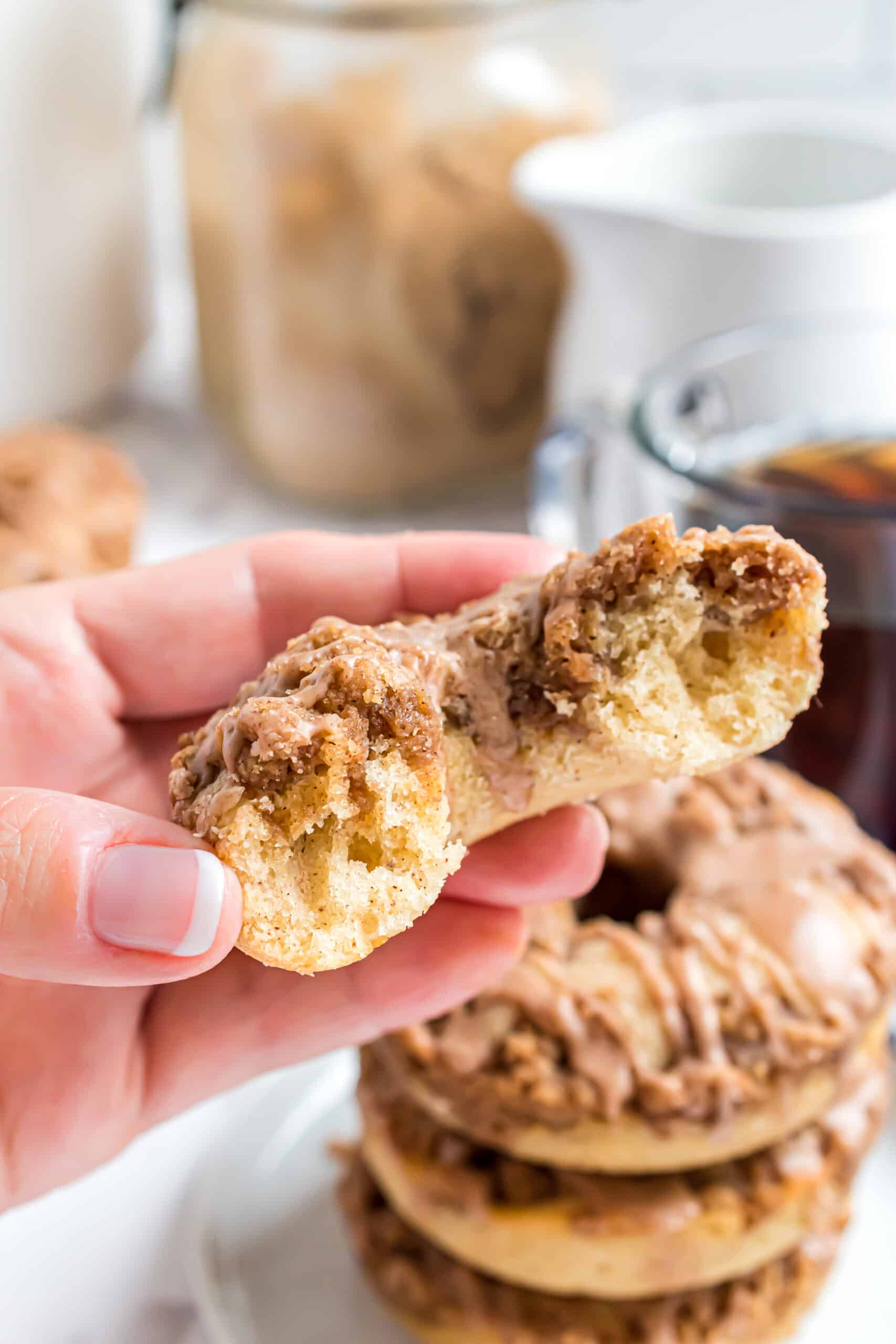 Cinnamon donut with one bite taken.