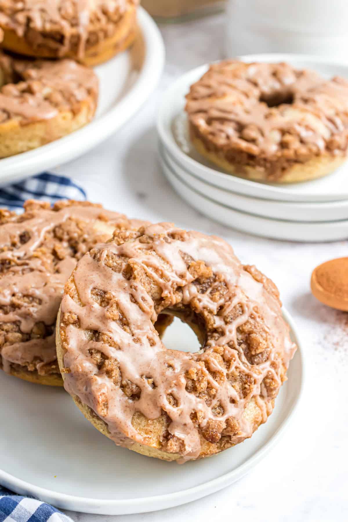 Cinnamon donuts with streusel on a white plate.