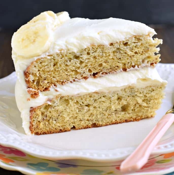 Slice of b anana cake on white plate.