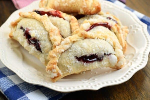 Combining strawberry and blueberry pie filling results in the most delicious, baked Berry Hand Pies. Perfect for summer, holidays, or anything in between! #handpies #summer #berries #berrypie #pie #baking