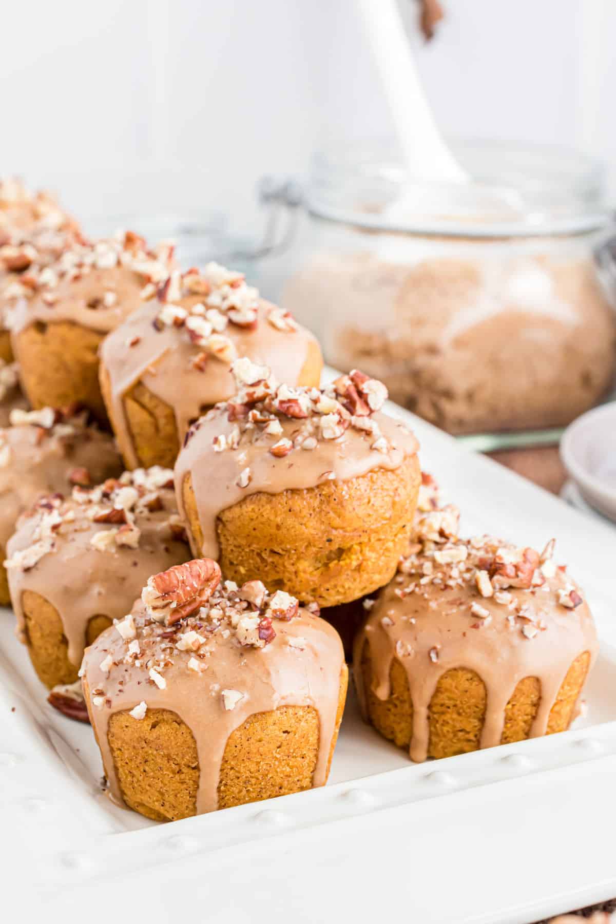 Mini pumpkin muffins topped with a pecan maple glaze.