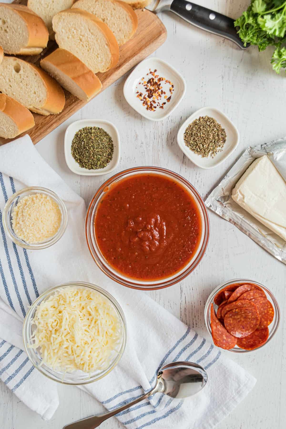 Ingredients needed for pepperoni pizza dip, including cream cheese, pizza sauce, pepperoni, and cheese.