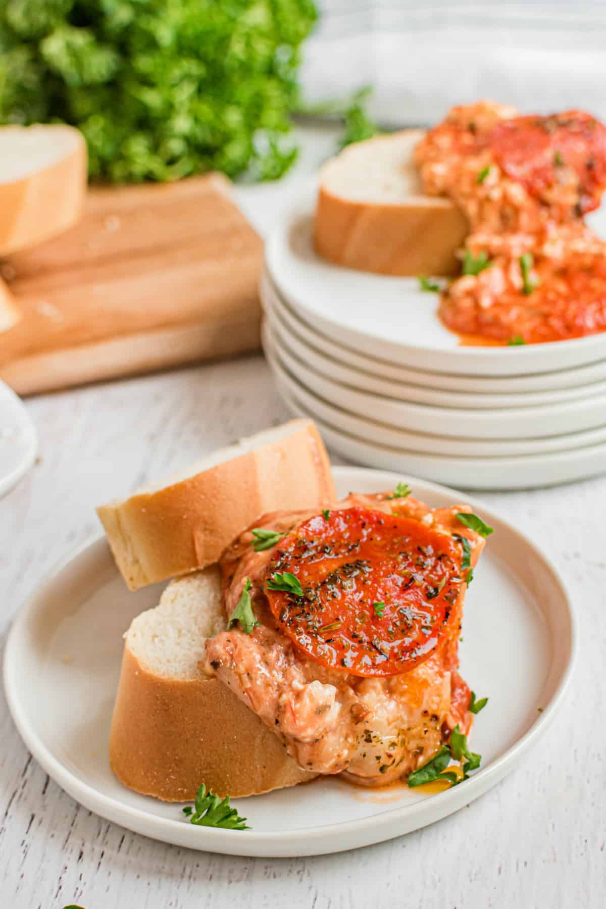 Pepperoni pizza dip on a slice of french bread on a white plate.