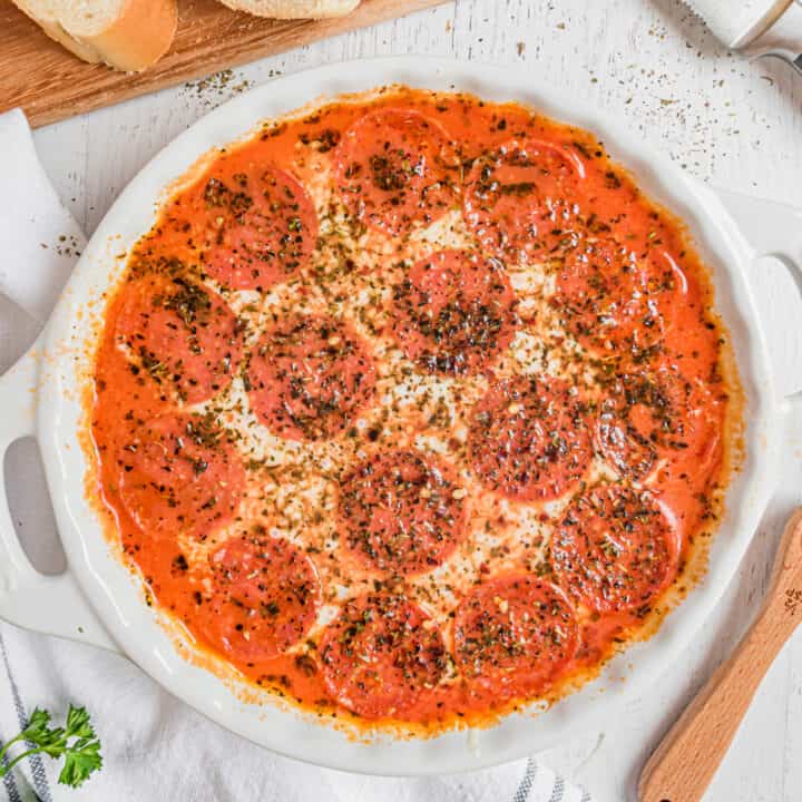 Pepperoni pizza dip in a round white pie plate.