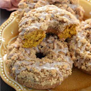 Pumpkin donuts on a yellow plate.