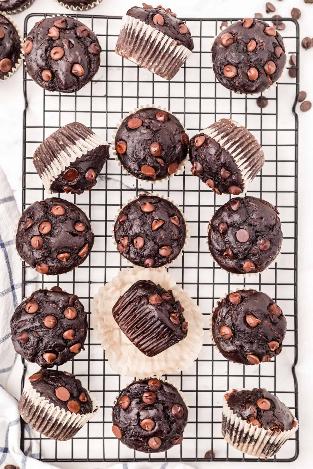 Zucchini muffins with chocolate on a wire cooling rack.