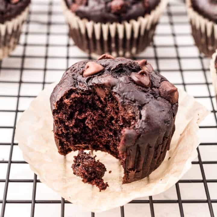Chocolate muffin with zucchini and one bite removed.