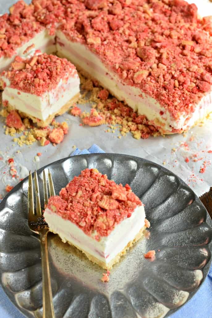 Slice of strawberry shortcake ice cream on a silver plate with a fork.