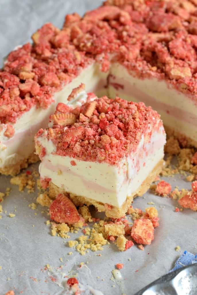 Square of strawberry shortcake ice cream in the pan with crumbs all around it.