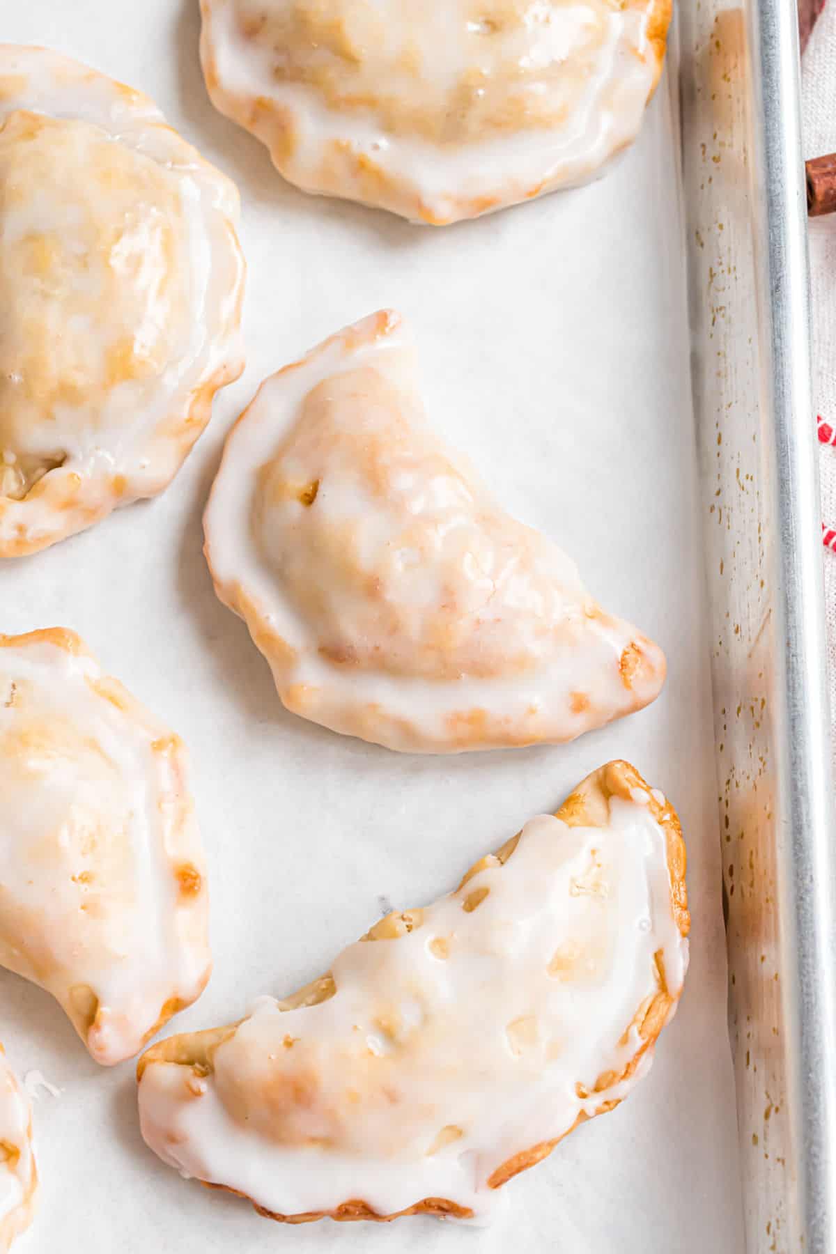 Iced hand pies on a cookie sheet.