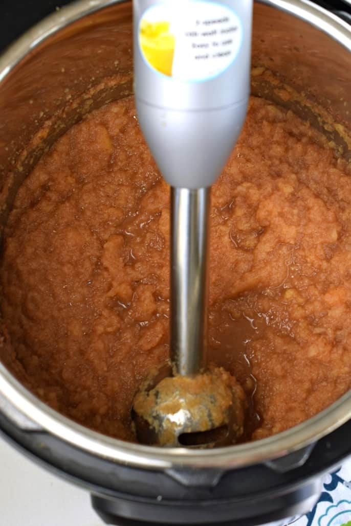 Instant pot with apple sauce and immersion blender.