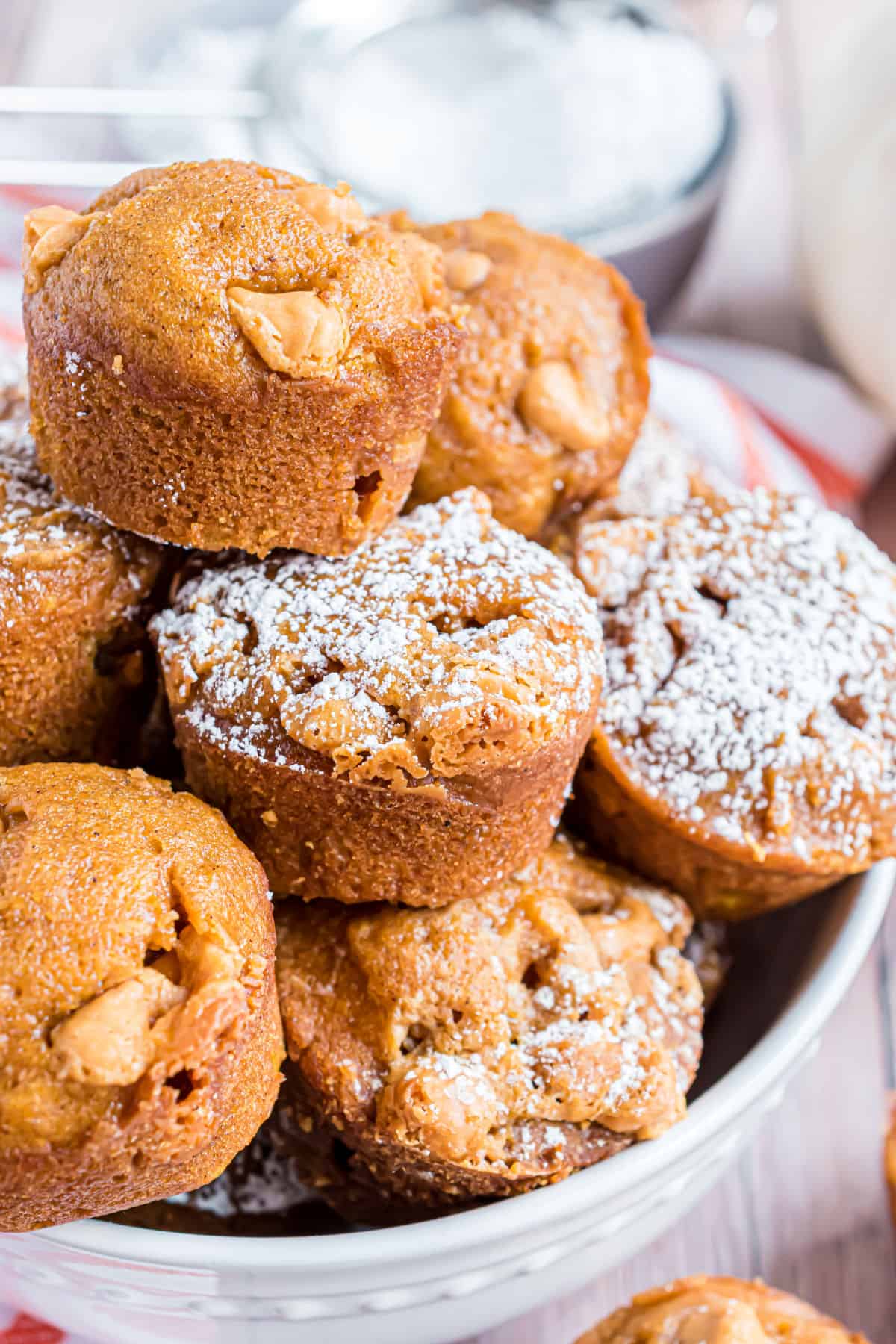 Mini pumpkin muffins with butterscotch morsels in a white bowl.