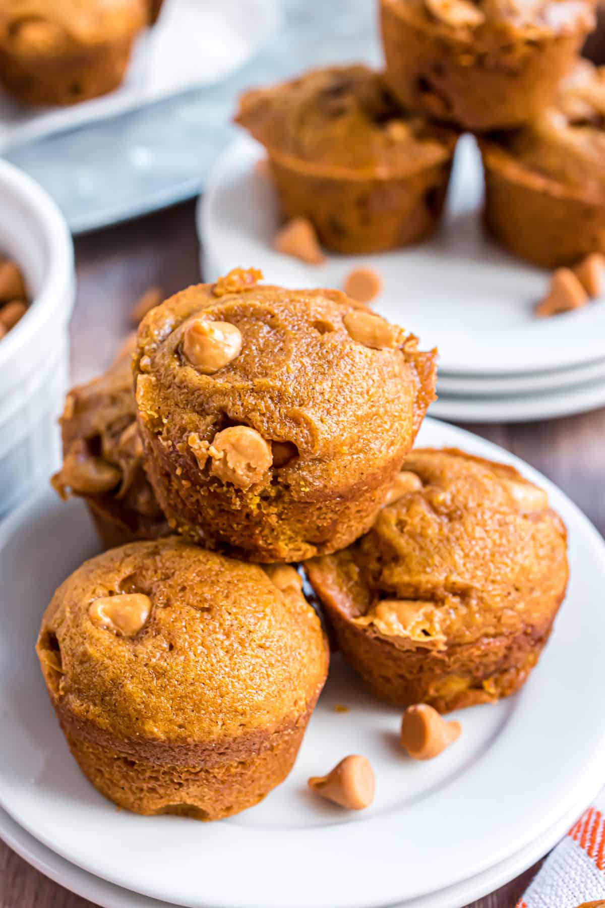 Stack of mini butterscotch pumpkin muffins on a white plate.