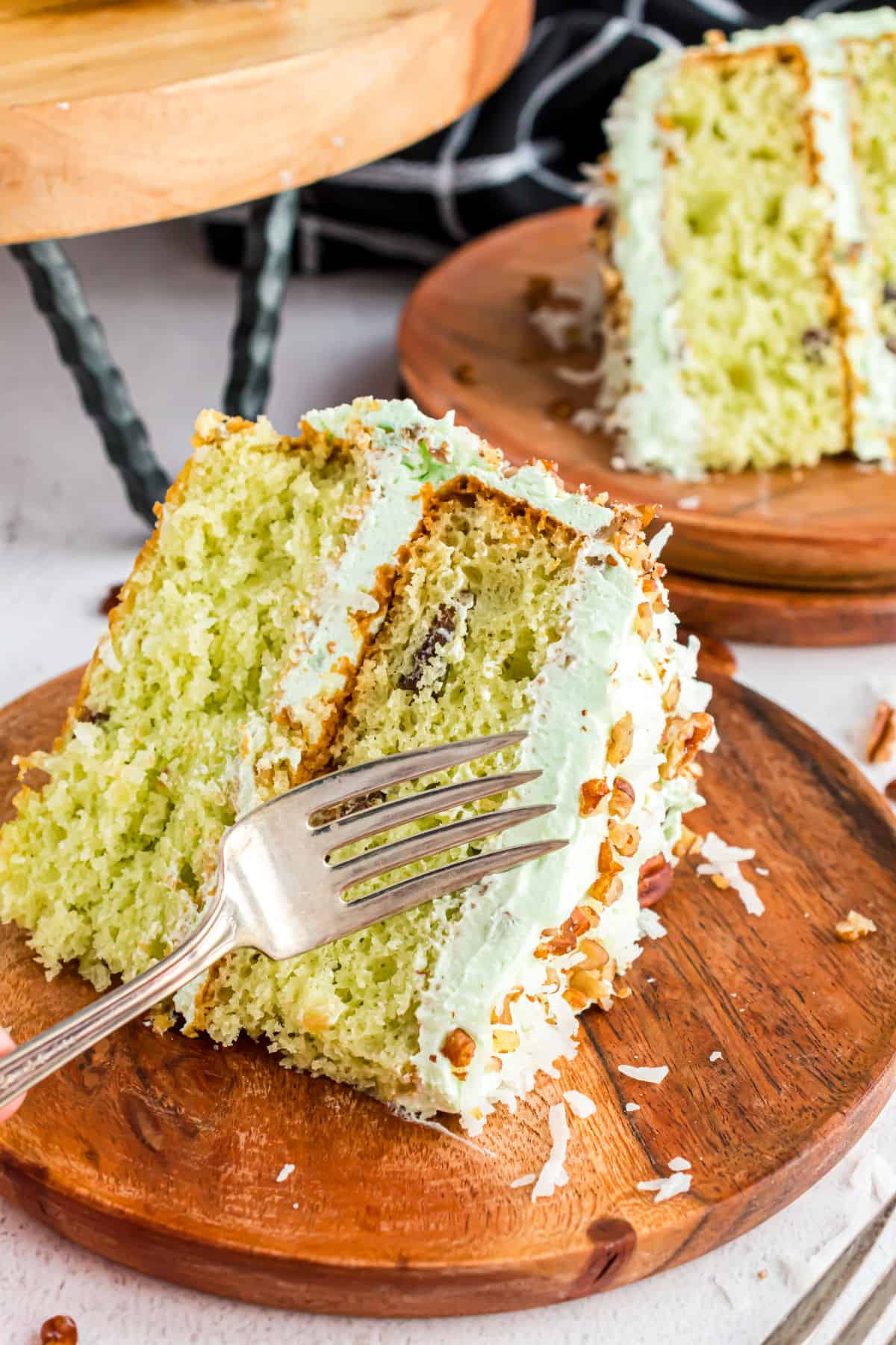 Slice of watergate cake with a fork taking a bite.
