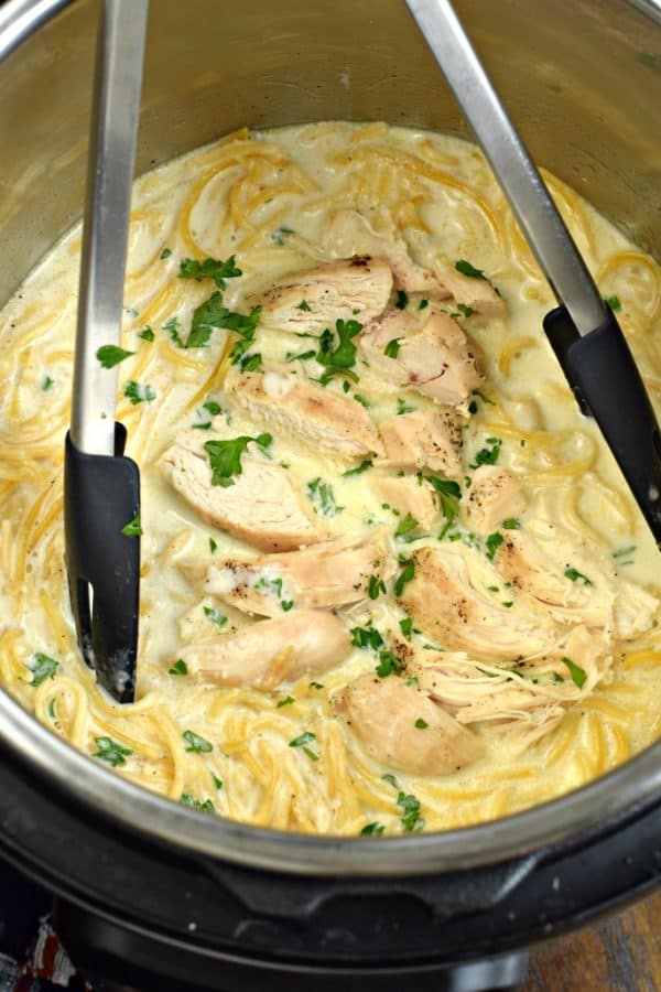 SKINNY Instant Pot Chicken Alfredo with tongs