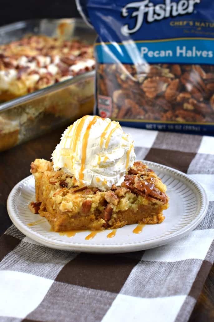 Pumpkin Dump Cake recipe served with whipped cream and caramel