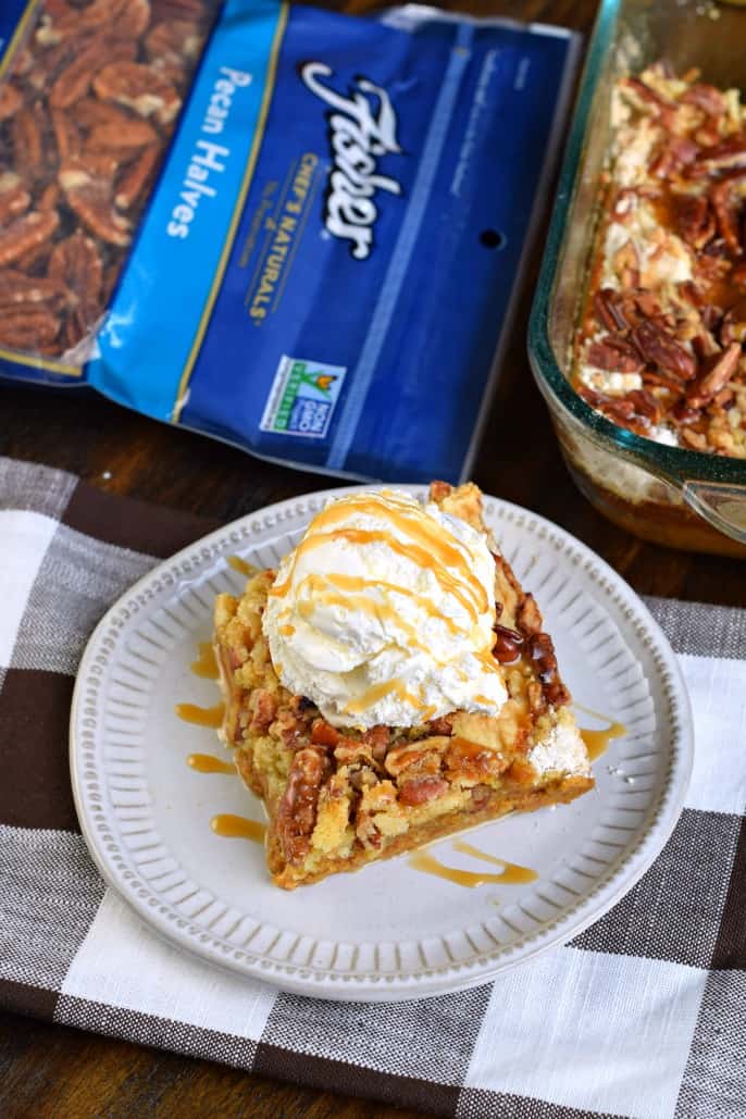 Pumpkin cake slice on white plate with ice cream and caramel.