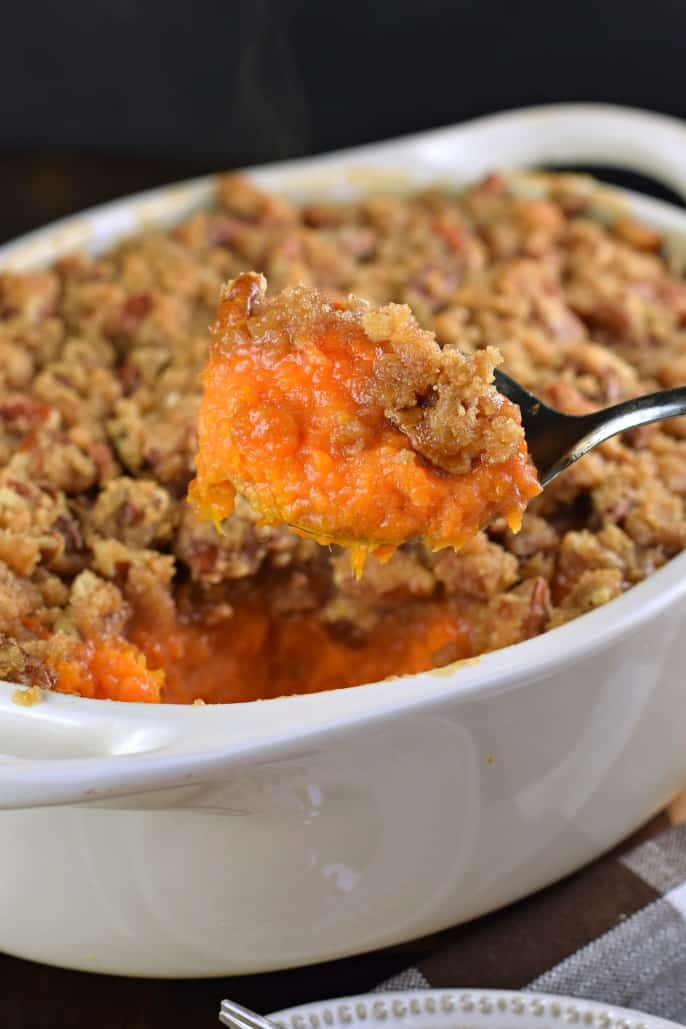 Grande cucchiaio di purè di patate dolci in una teglia bianca.