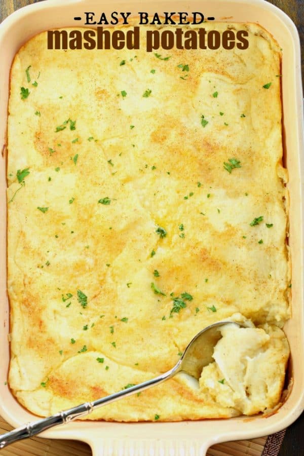 Easy baked mashed potatoes in 13 x 9 with spoon, sprinkles of parsley on top.