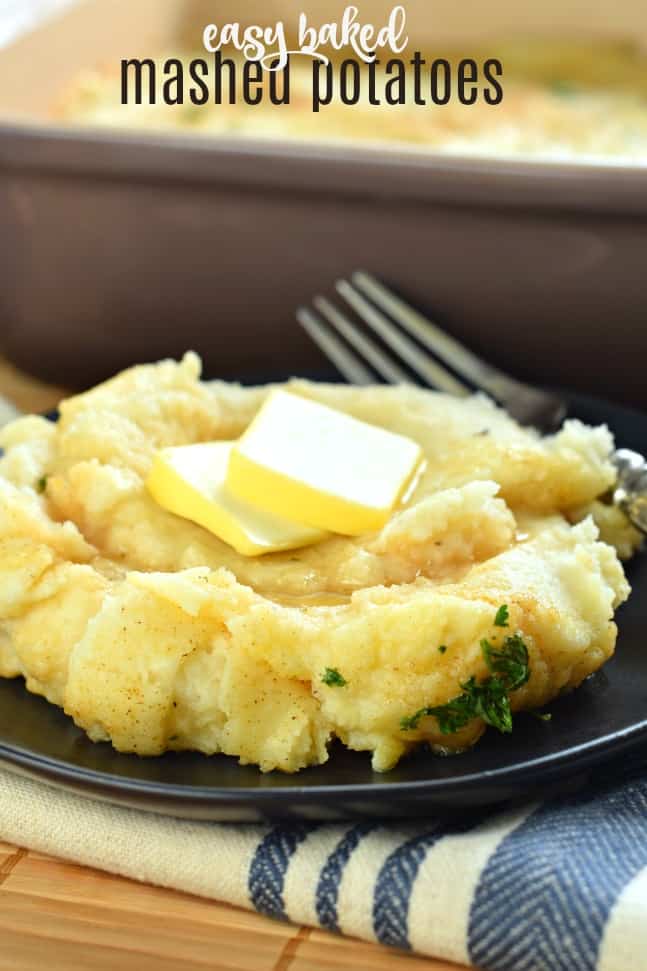 Black plate with scoop of baked mashed potatoes, two pats of butter and fork.