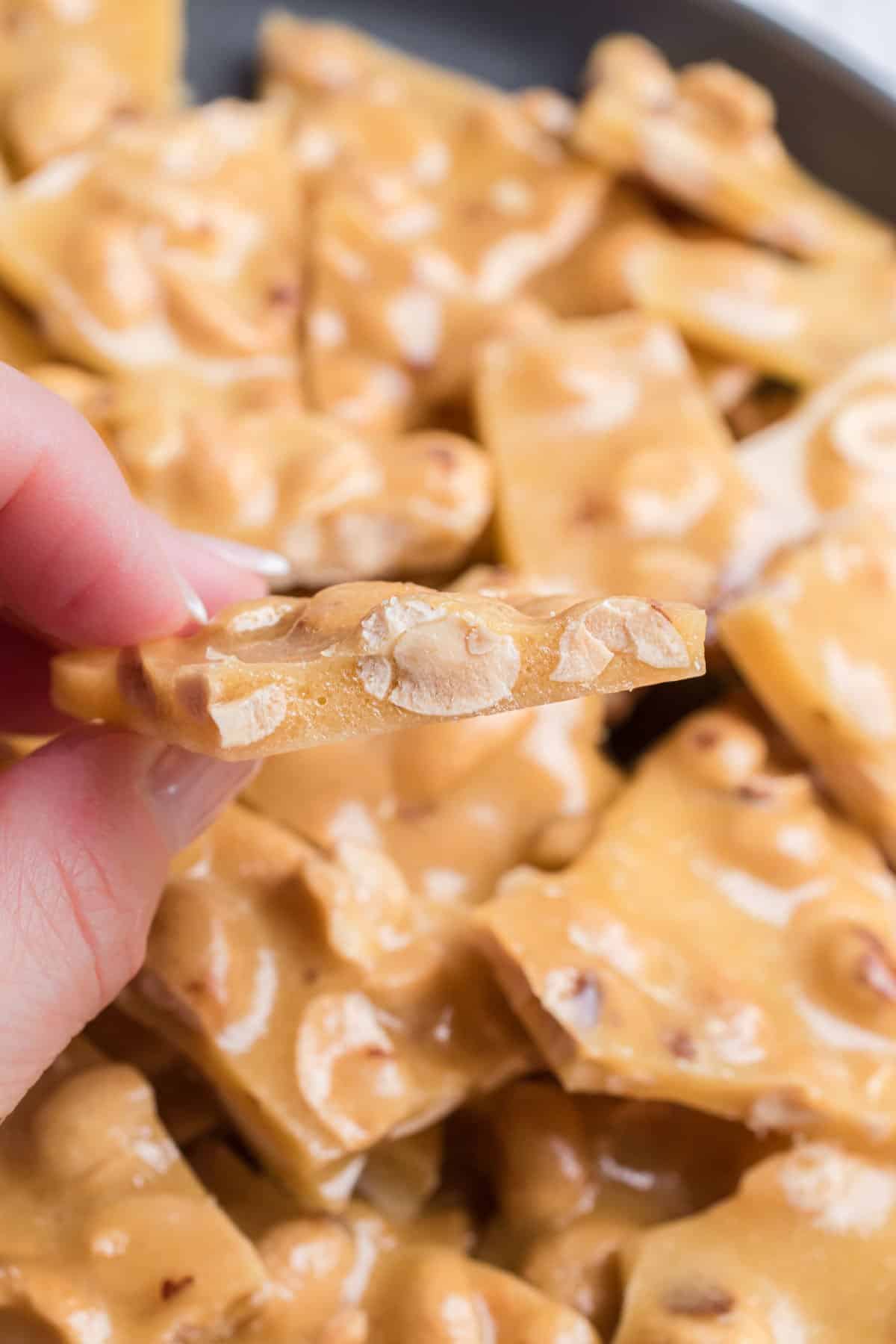 Bite of peanut brittle showing peanuts.