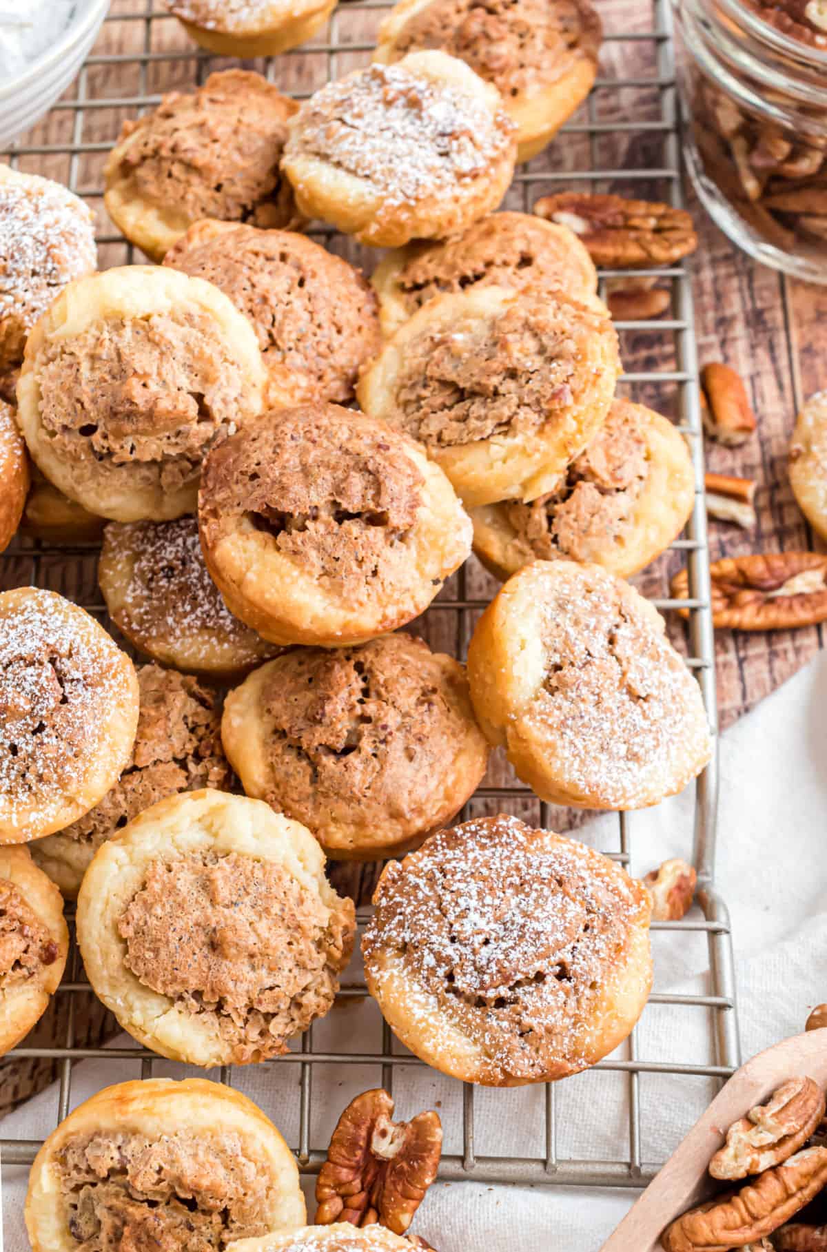 Pecan tassies cookies stacked on a wire cooling rack after baking.