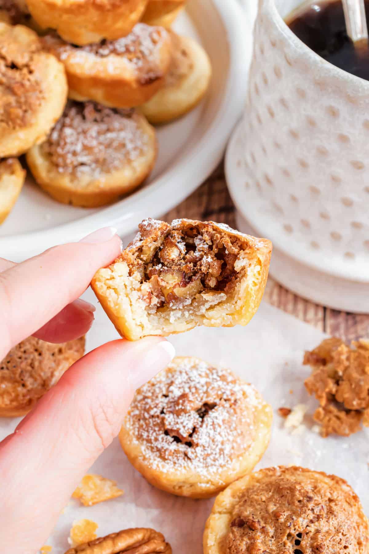 Pecan tassie with a bite taken out to reveal pecan pie filling.