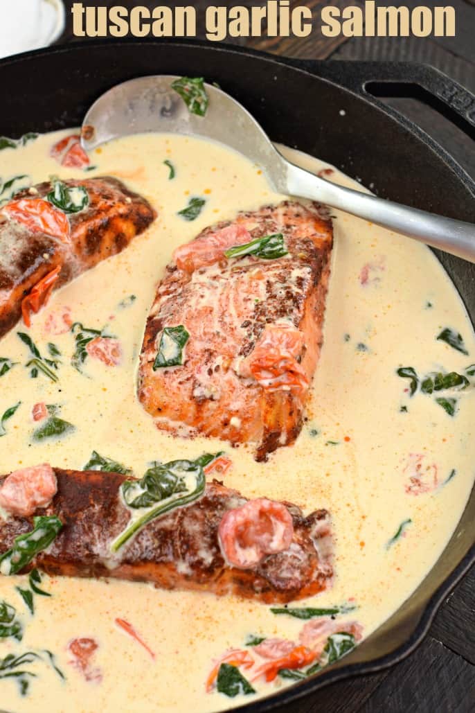 Blackened salmon in a skillet with garlic sauce.