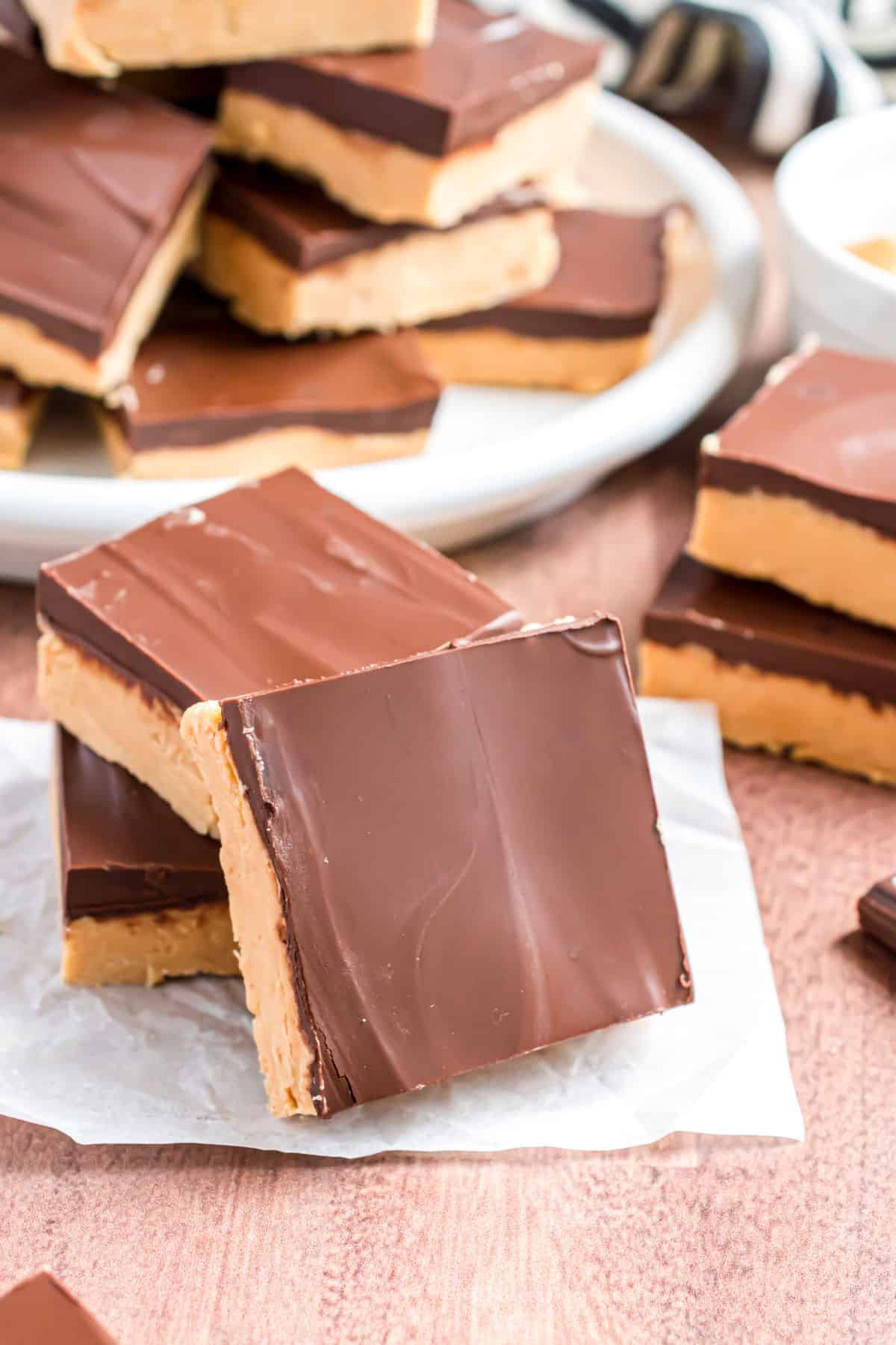 Buckeye bars stacked on white parchment paper.