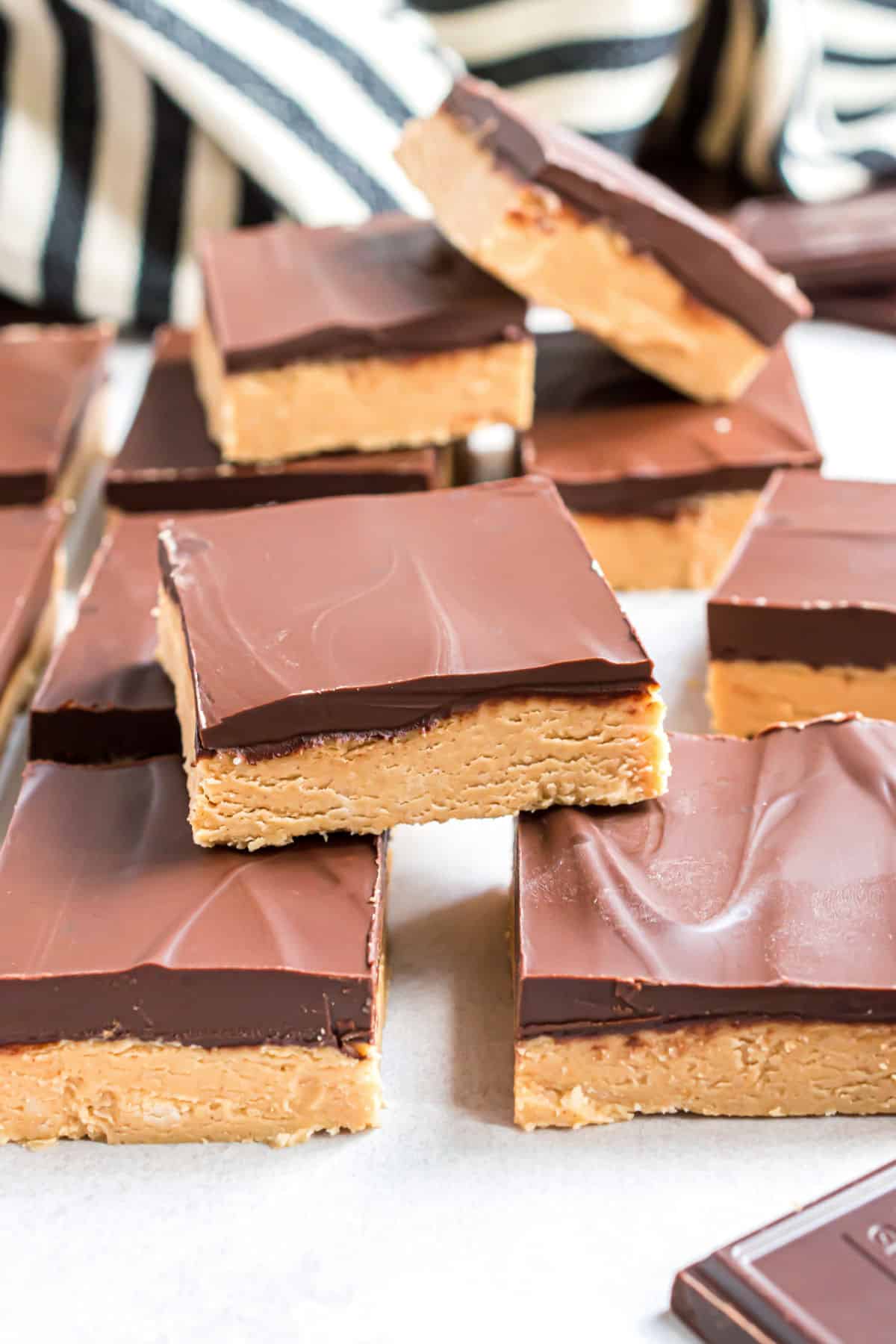 Peanut butter bars stacked on a white plate.