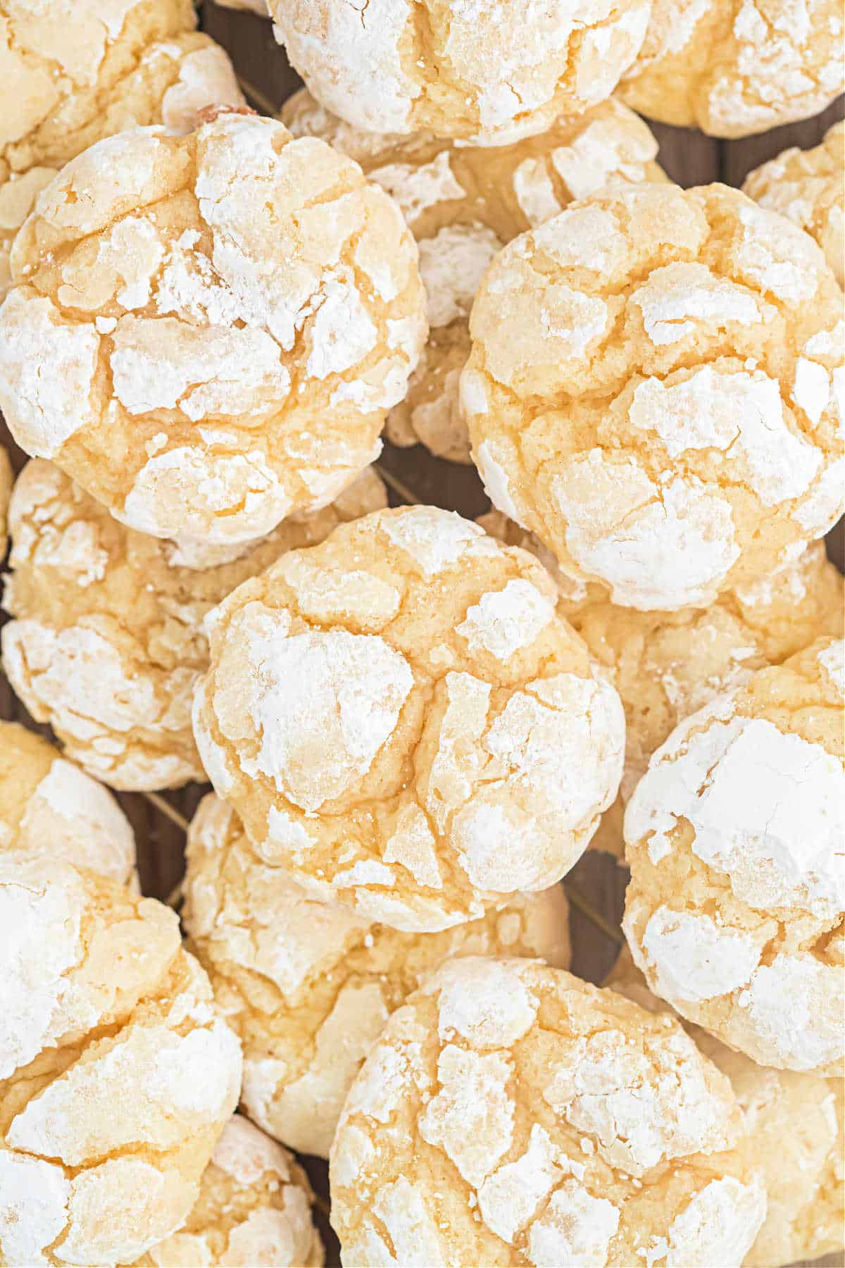 Butter cookies with powdered sugar stacked on wire racks.