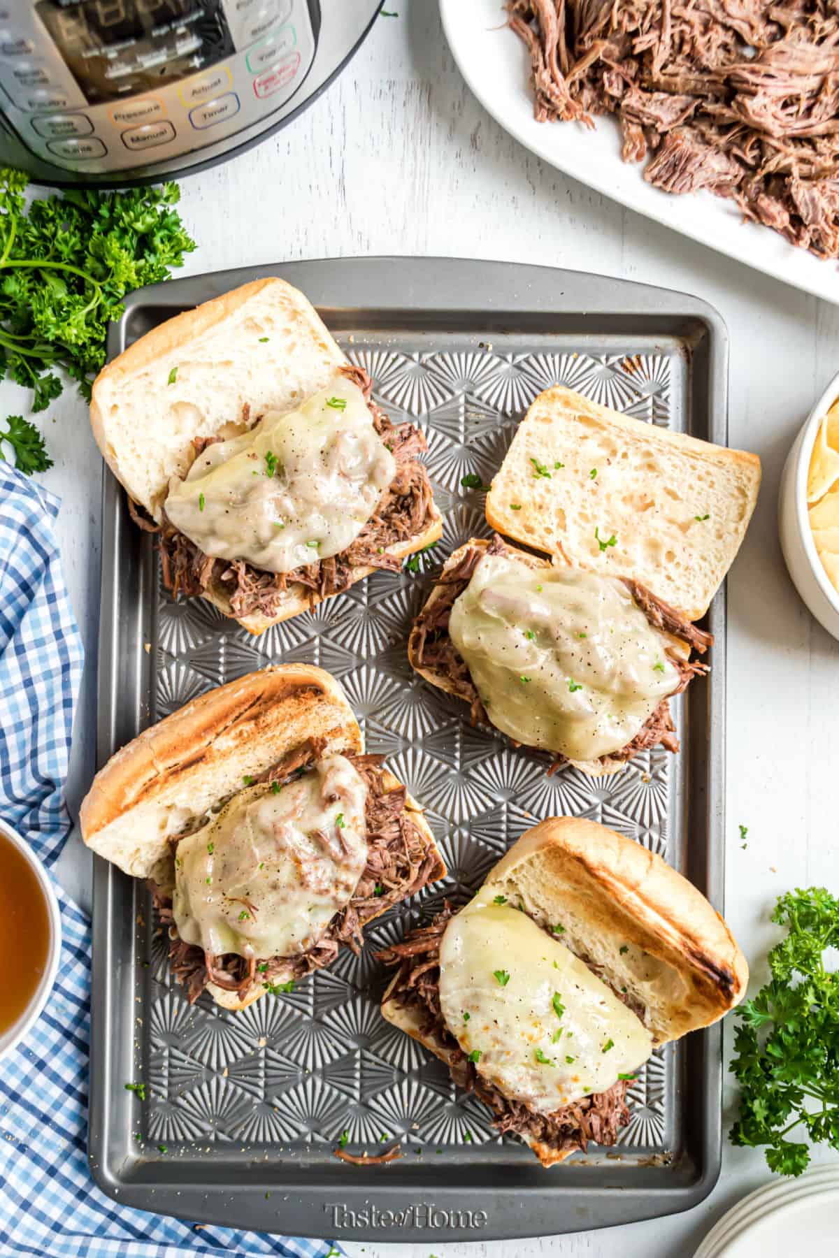 French dip sandwiches on a baking sheet to melt cheese in oven.
