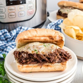 Tender roasted, French Dip Sandwiches cooked in the Instant Pot. Piled on a crusty french roll with extra cheese, this flavorful dinner is then dipped in au jus!