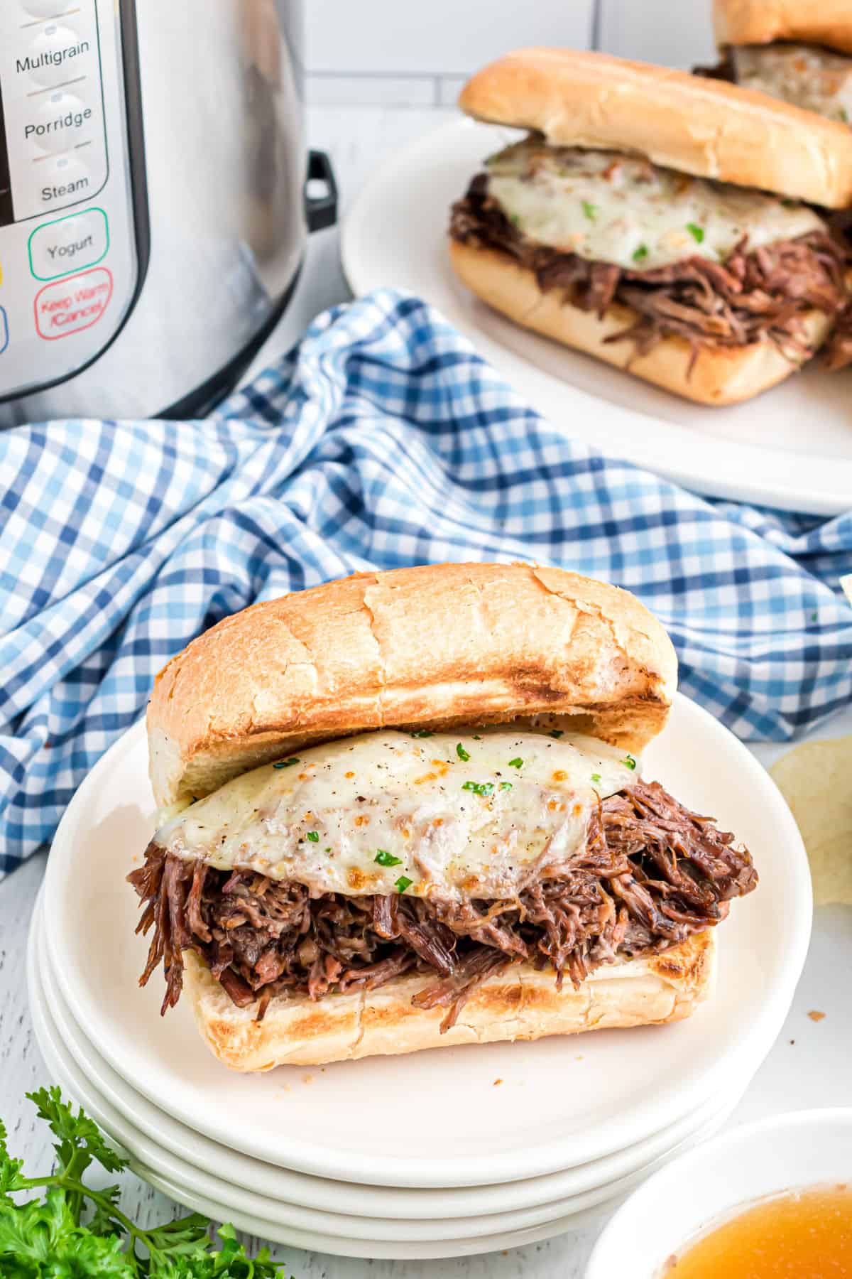 French dip sandwich on a stack of plates.