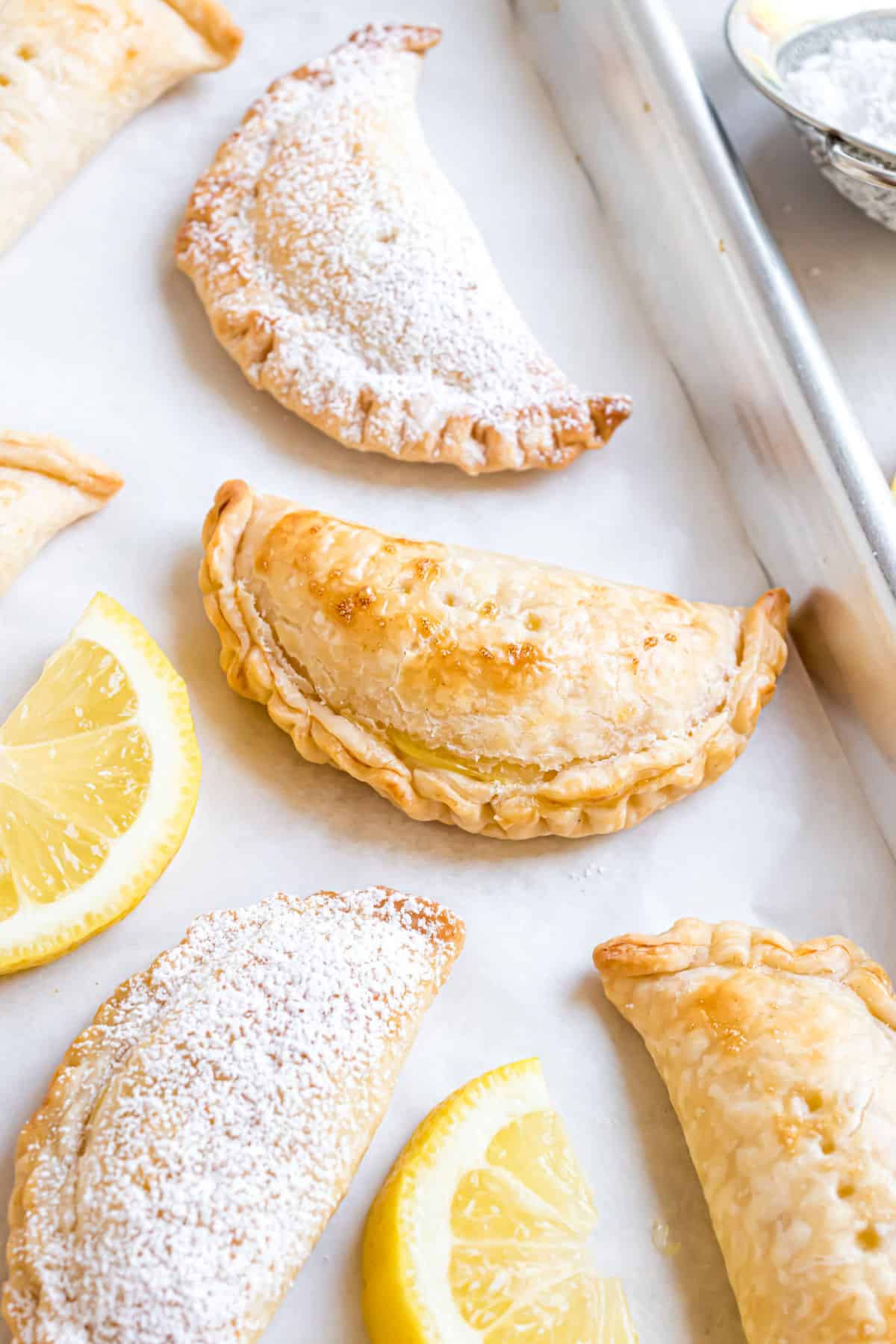 Lemon hand pies baked on a cookie sheet.
