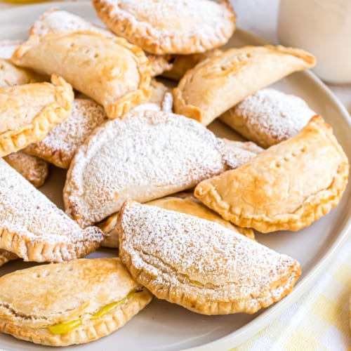 Flaky lemon hand pies on a white plate.