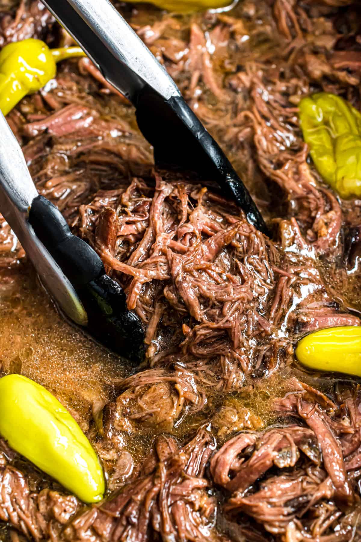 Mississippi pot roast shredded in crockpot with pepperoncini peppers.