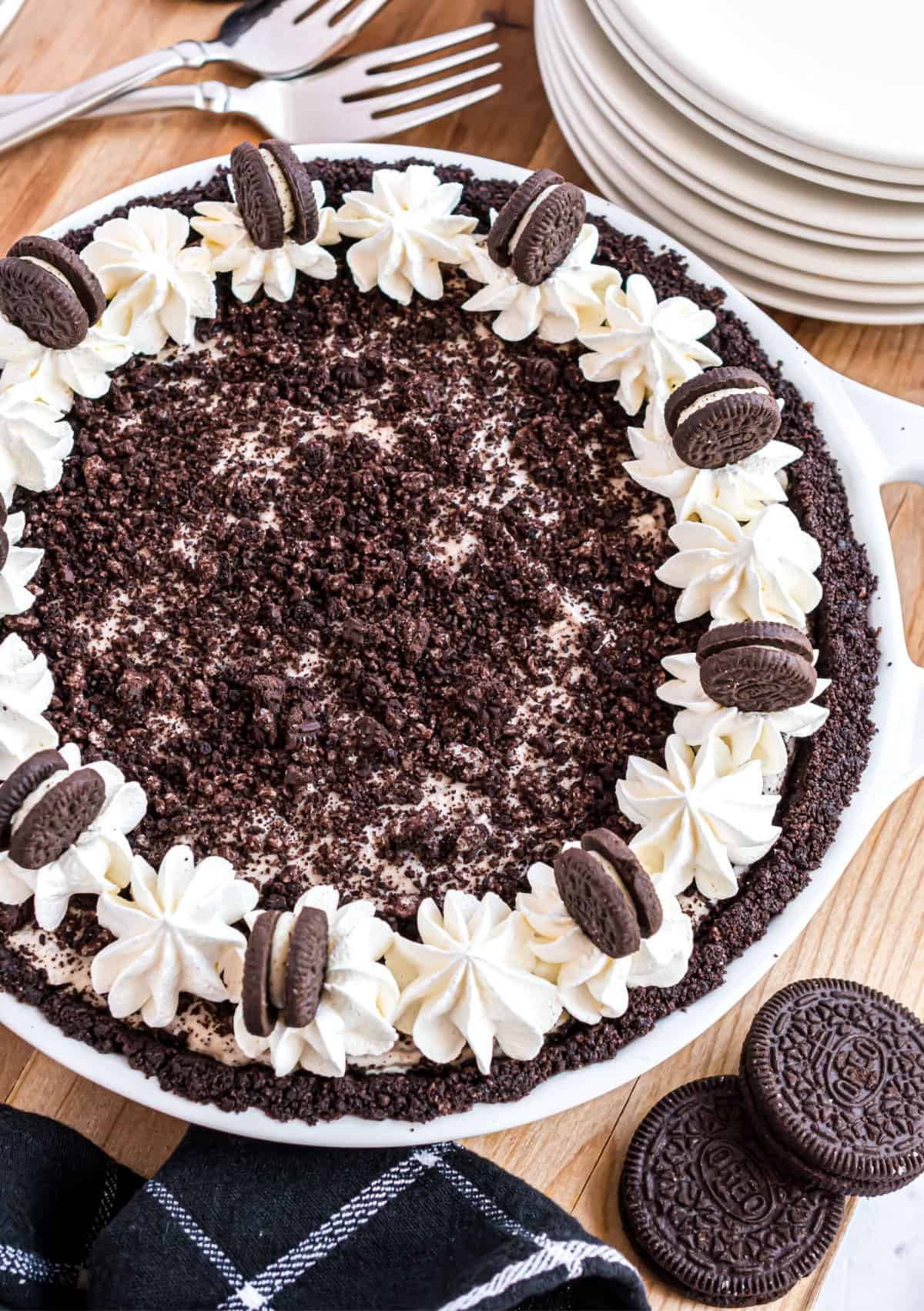Oreo cheesecake garnished with whipped cream and crushed oreo cookies.