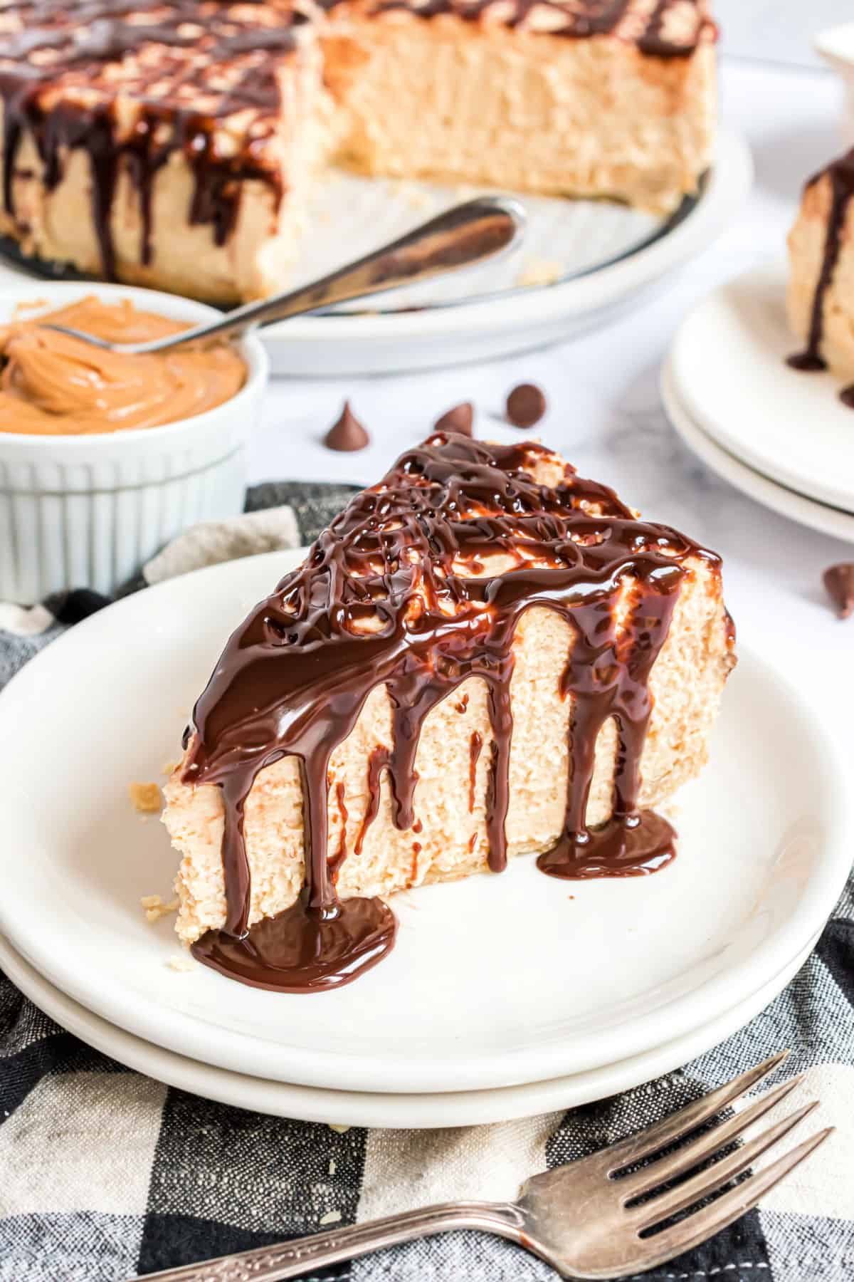Slice of peanut butter pie with chocolate ganache on top.