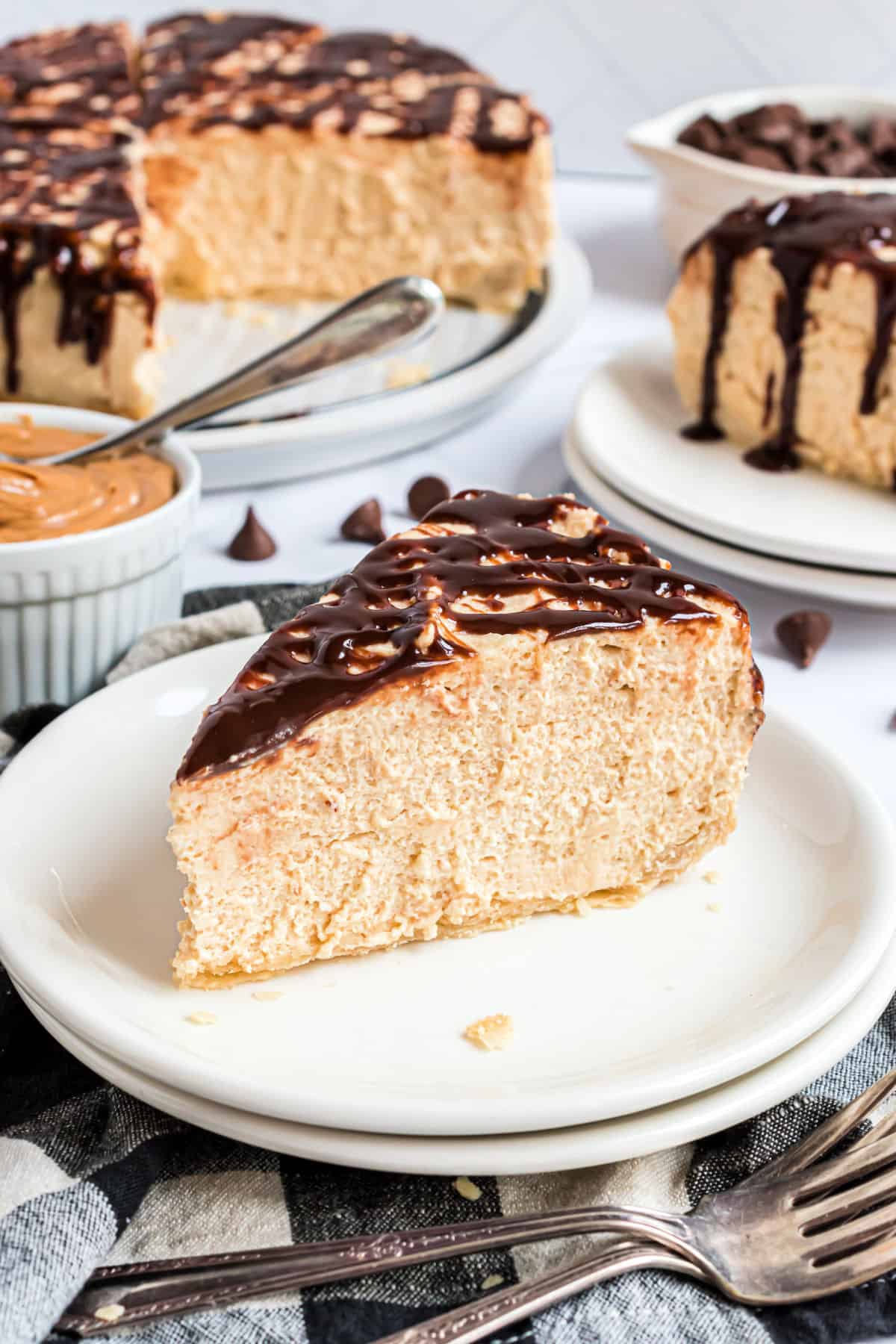 Slice of peanut butter pie on a stack of white plates.