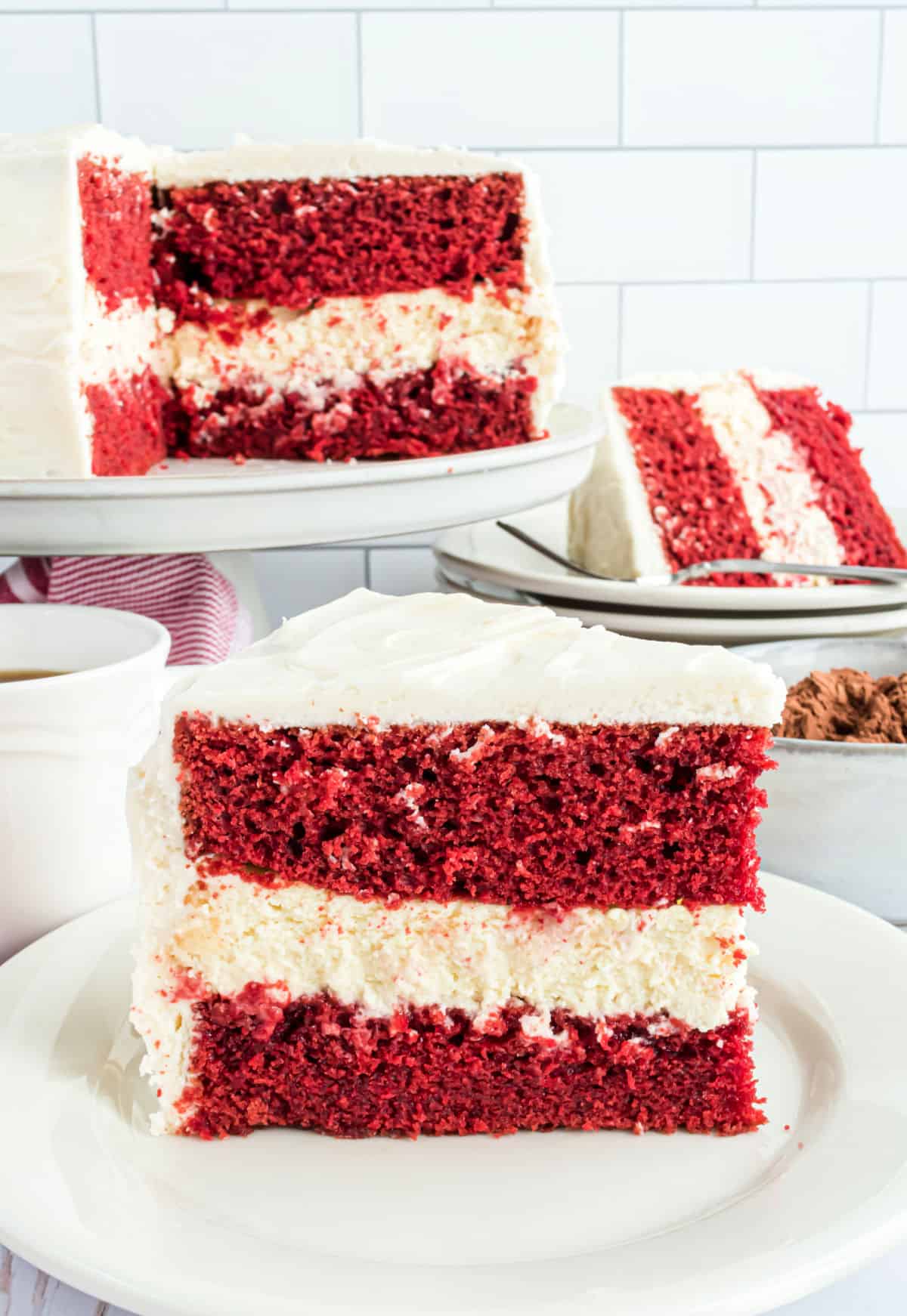 Slice of red velvet cake with cheesecake filling on a white plate.